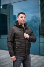 Куртка черного цвета, в полуоборота, застегнутая