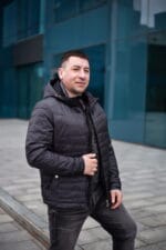 Куртка черного цвета, в полоборота, расстегнутая