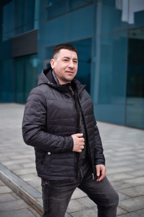 Куртка черного цвета, в полоборота, расстегнутая