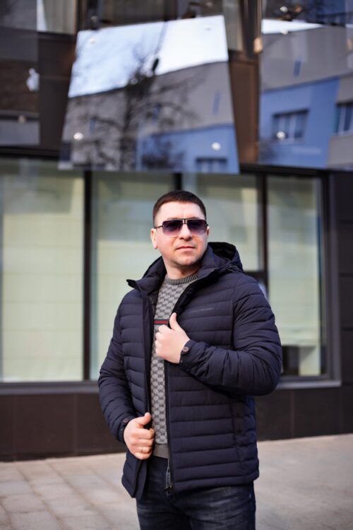 Темно-синяя мужская куртка, вид спереди в полуобороте, расстегнута