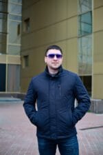 Темно-синя чоловіча куртка, панорамний план, руки в кишенях