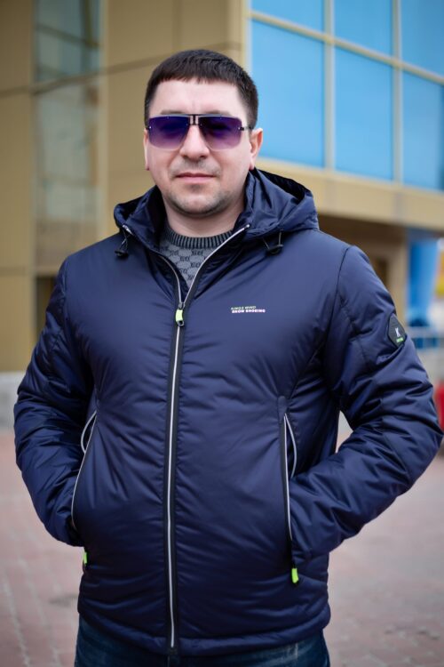 Куртка темно-синего цвета, крупный план, руки в карманах