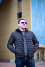 Легка весняна куртка, чорний колір, розстібнута, руки в кишенях.
