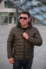 Стьобана зимова куртка у кольорі хакі, вигляд спереду, застібнута.
