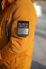 Шеврон бренду Black Vinyl на лівому рукаві зимової куртки.