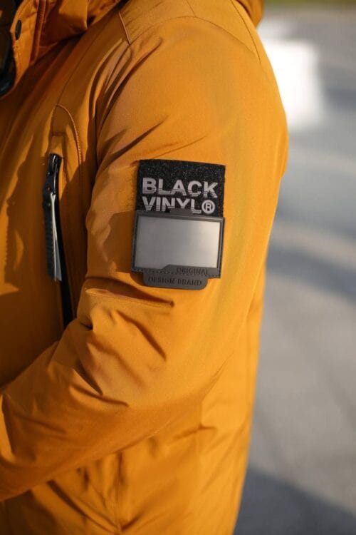 Шеврон бренда Black Vinyl на левом рукаве зимней куртки