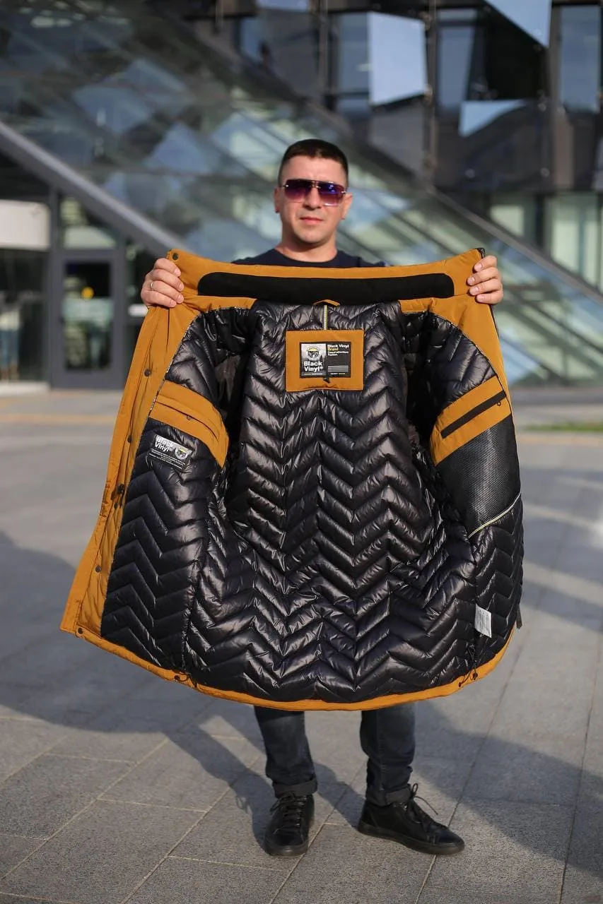 Модель держит снятую зимнюю куртку Black Vinyl С21-1876L, демонстрируя фирменную подкладку.