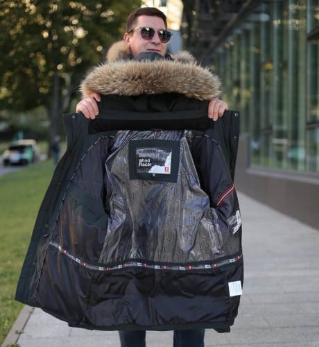 Як вибрати розмір чоловічої куртки – чоловік тримає розкриту куртку в руках